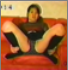 An attractive Asian girl farts while sitting on a sofa.